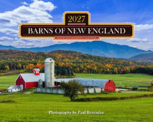 Farm scene with a red barn and silo, green fields, autumn trees, and distant blue mountains under a clear sky; watermark at bottom.