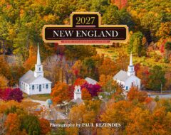 Autumn aerial view of a white church campus surrounded by bright fall foliage; calendar title reads '2027 NEW ENGLAND' on a decorative badge.