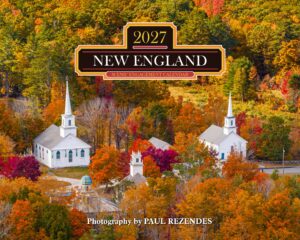 Autumn aerial view of a white church campus surrounded by bright fall foliage; calendar title reads '2027 NEW ENGLAND' on a decorative badge.