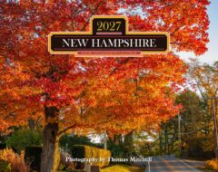 Autumn scene of orange-red maple leaves along a road, with a decorative calendar banner reading 'New Hampshire 2027' and 'Scenic Engagement Calendar' across the center.